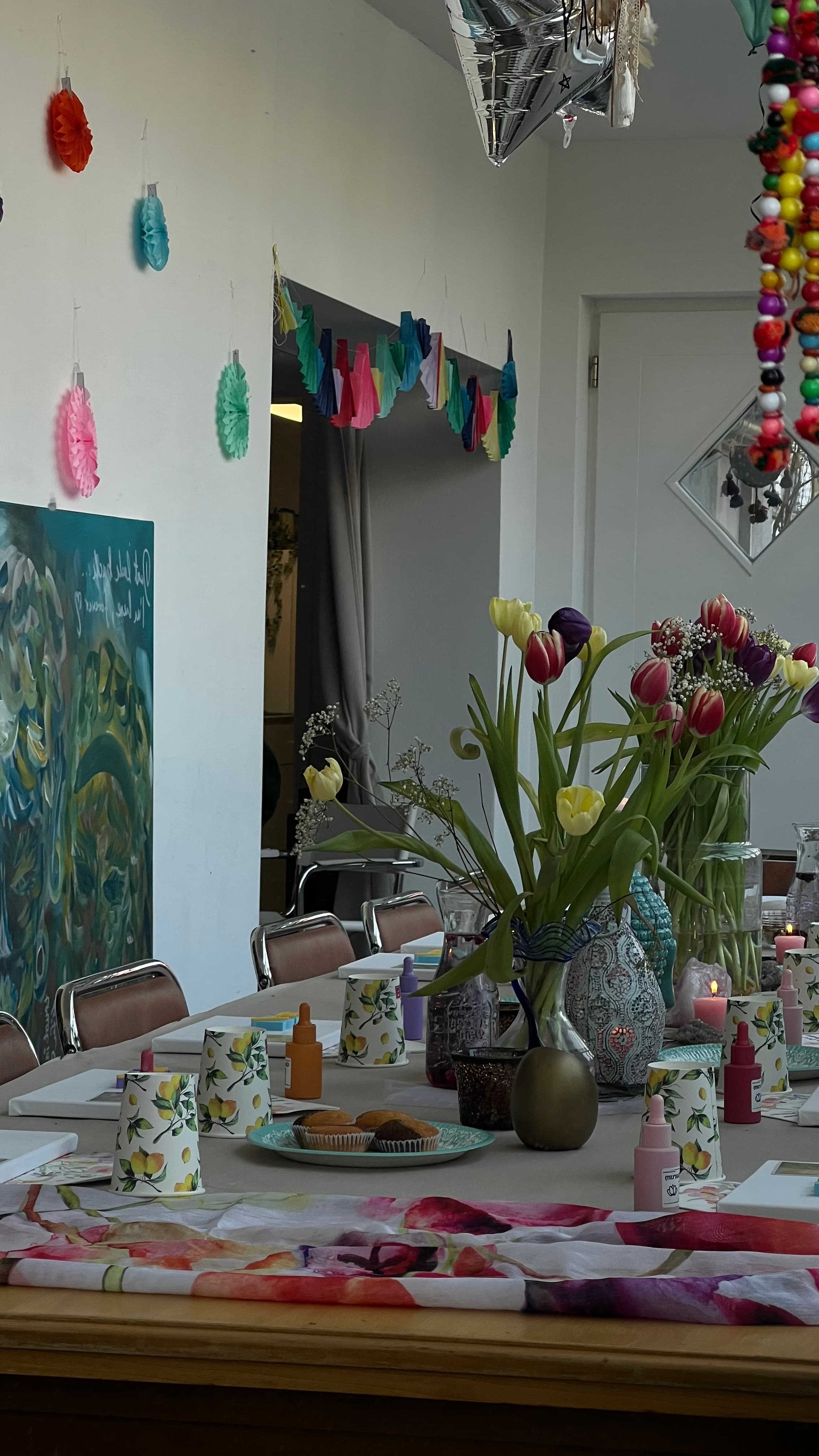 Wintergarten des HeimART Studios mit Oberlicht, Pflanzen, Traumfänger und langem Tisch — warmes Tageslicht